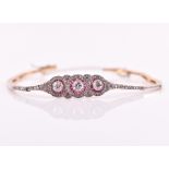 A late Art Deco diamond and ruby bracelet centred with three old round-cut diamonds, within a