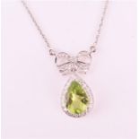 A diamond and peridot drop pendant necklace set with a pear-cut peridot with a diamond border,