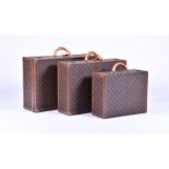 A graduated set of three Louis Vuitton suitcases with monogrammed exteriors, tan leather handles and