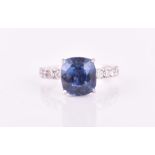 An 18ct white gold, diamond, and sapphire ring set with a rectangular cushion-cut sapphire of