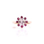 A 14ct yellow gold, diamond and ruby cluster ring set with an oval cushion-cut diamond of