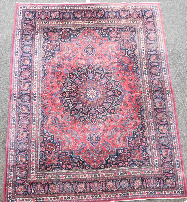 A large Persian Isfahan carpet designed with a red ground central medallion surrounded with shah