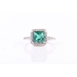 A 14ct white gold, diamond, and emerald ring set with a princess-cut emerald of approximately 1.40