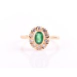 An 18ct yellow gold, diamond, and emerald cluster ring set with a mixed oval-cut emerald, surrounded