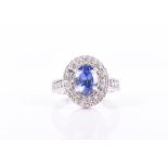 A 14ct white gold, diamond, and tanzanite ring set with an oval-cut tanzanite of approximately 1.