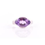 A 9ct white gold, diamond, and amethyst ring set with a faceted marquise-cut amethyst, set