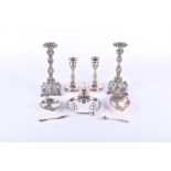 A pair of white metal cast candlesticks with embossed decoration, in the Victorian style, marked