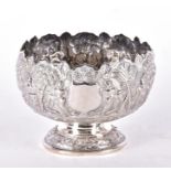 A 20th century Burmese white metal pedestal bowl typically decorated with a figures and trees in