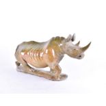 A 20th century hardstone rhinoceros  modelled in a running pose, 46 cm x 25 cm.