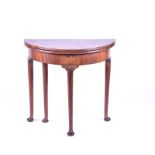 An eighteenth century mahogany demi-lune tea table possibly George II, the hinged top on a single