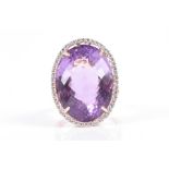 A 14ct yellow gold, diamond, and amethyst cocktail ring set with a large faceted amethyst of