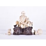 A Japanese Meiji period carved ivory okimono of a musician with assorted instruments and