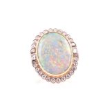An 18ct yellow gold, diamond, and doublet opal cocktail ring set with a flat oval opal, surrounded