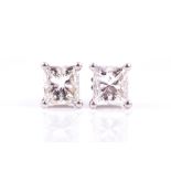 A pair of diamond stud earrings each claw-set with a princess-cut diamond measuring approximately