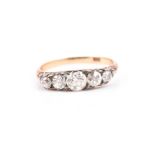 An 18ct yellow gold and diamond ring set with five graduated old round-cut diamonds of approximately