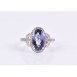 A diamond and tanzanite ring the mixed oval-cut tanzanite measuring approx 12 mm x 6.9 mm, in