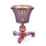 A 19th century, possibly Regency mahogany jardiniere with lift out brass liner, slatted sides on a