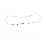 A yellow gold, diamond, and amethyst necklace suspended with five graduated heart-shaped