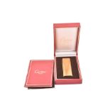 A Cartier Paris gold-plated cigarette lighter in a fitted Cartier box, the ribbed lighter numbered