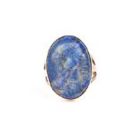 A yellow metal and lapis lazuli cameo ring the oval lapis carved with an image of a young girl
