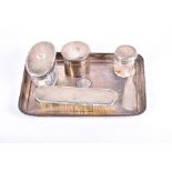 An early 20th silver five-piece dressing table set (associated), comprising a rectangular tray,