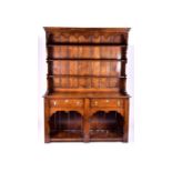 A large 18th century style oak dresser the top with three shelves, on a base with two drawers and