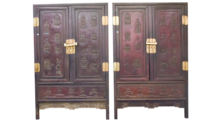 A pair of early 20th century Chinese hardwood cabinets with brass mounts, the panelled doors with