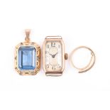 A yellow metal and blue topaz pendant set with a rectangular-cut topaz within an openwork floral