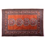 An Eastern wool rug, probably Caucasian, the centre panel with four geometric cartouches on brown