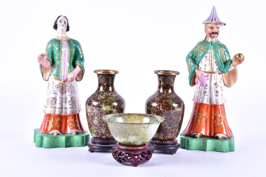 A pair of early 20th century porcelain figures of an Oriental couple hand painted with gilt