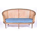 A French Louis XVI style giltwood kidney shaped bergere sofa with curved back carved with