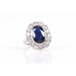 A diamond and sapphire cocktail ring of oval cluster form, set with a mixed oval-cut sapphire,