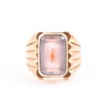 A yellow metal and amethyst ring inset with a rectangular-cut pale amethyst, the shank with