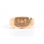 An 18ct yellow gold gents ring engraved with two figures and a shield, bearing the inscription '