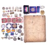 A group of militaria and medallions comprising a group of military cap badges and sweetheart