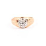 A yellow metal and diamond ring the tapered band inset with a floral cluster of round-cut