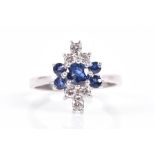 An 18ct white gold, diamond, and sapphire cluster ring set with five round-cut sapphires to the