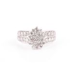 A 9ct white gold and diamond cluster ring set with an asymmetric cluster of round brilliant-cut