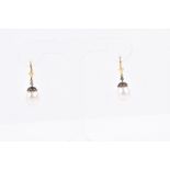 A pair of silver gilt, diamond, and freshwater pearl drop earrings each with a rounded pearl beneath