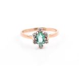 A 9ct yellow gold, diamond, and emerald ring set with a mixed oval-cut emerald of approximately 0.65