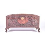 An early 20th century Chinese carved camphor wood chest the arched top, front, sides and back deeply