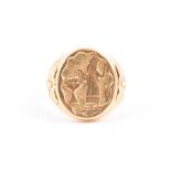 An unusual 18ct yellow gold ring the oval mount engraved with a scene of a robed figure with a
