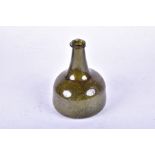 A late 17th or early 18th century green glass bottle of onion form, no seal mark present, 14.5 cm