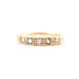 A yellow metal, diamond, and emerald ring the band pave-set with three round-cut diamonds and two