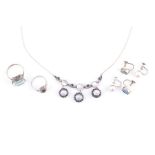 A silver, moonstone, and sapphire drop pendant necklace set with three moonstones and four