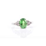 An 18ct white gold, diamond, and tsavorite ring set with a mixed oval-cut green garnet of