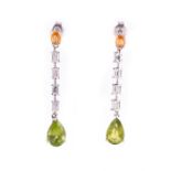 A pair of white metal, diamond, citrine, and peridot drop earrings each set with an oval-cut citrine