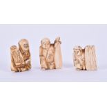 Three Meiji period ivory netsukes each modelled as an immortal holding a scroll, tallest 3.5 cm