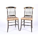 An ebonised pair of Victorian chairs, with hand painted gilt decorations of floral and dragon