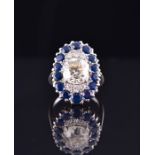 A 1960's diamond and sapphire ring of oval cluster form, centred with an old cushion-cut diamond